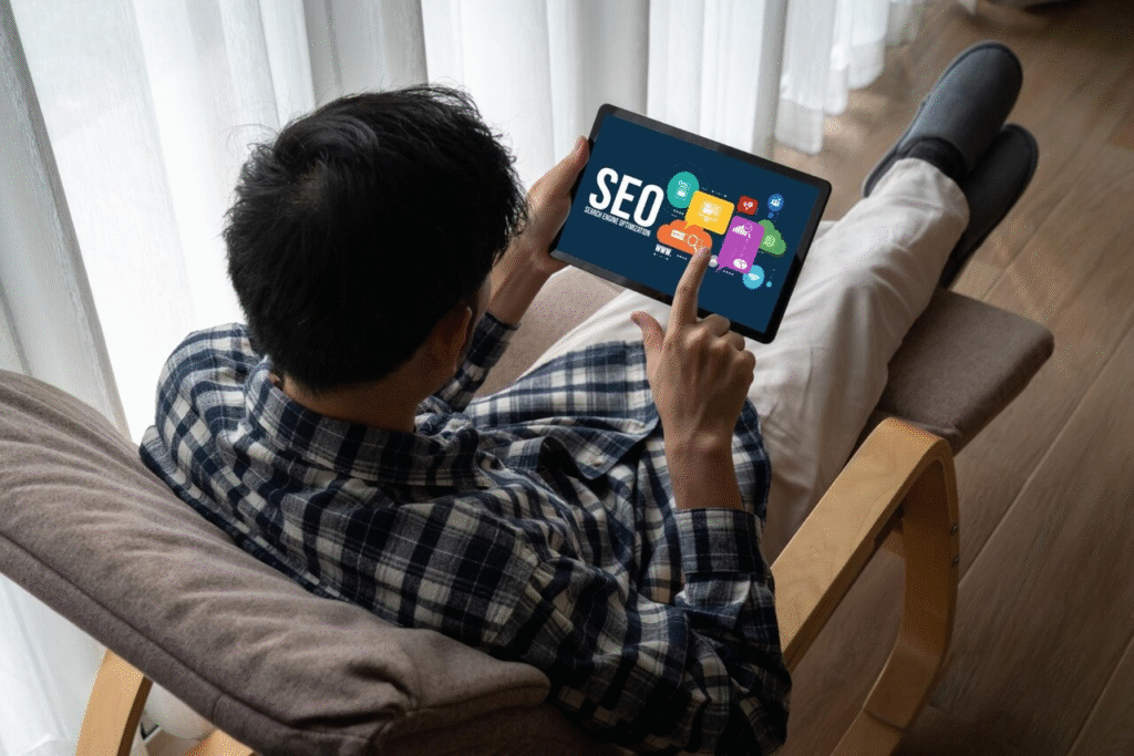 A Man focused on a tablet, researching SEO strategies in a modern office setting.