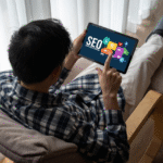 A Man focused on a tablet, researching SEO strategies in a modern office setting.