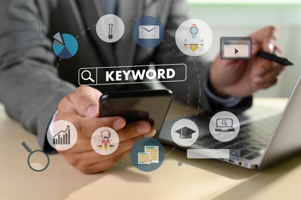 Business professional using laptop and smartphone with keyword ranking icons