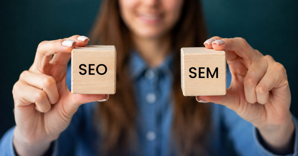 Woman holding SEO and SEM wooden blocks.