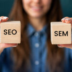 Woman holding SEO and SEM wooden blocks.
